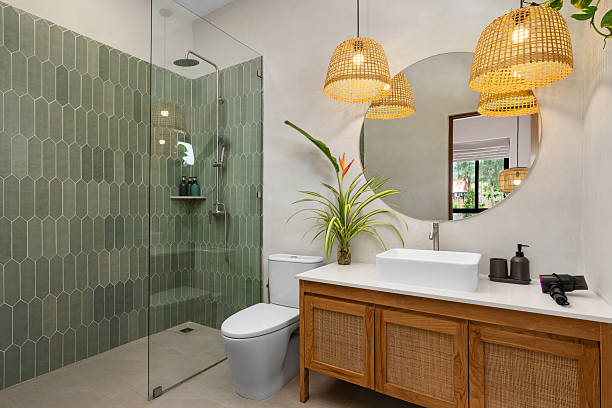 Elegant bathroom featuring a walk-in shower, wooden vanity, and a round mirror. Built by the best bathroom remodeling company in Bee Cave TX