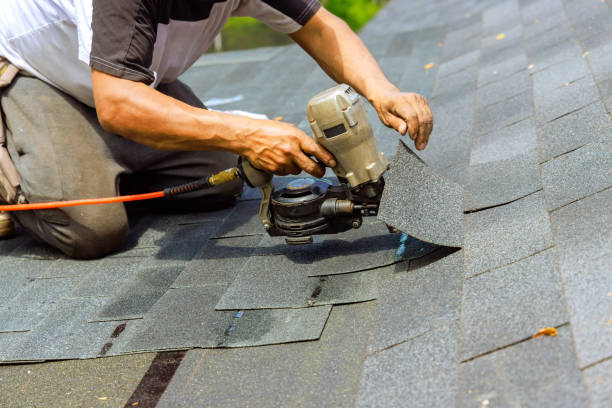 Roofing contractors in Dripping Springs During installation of new bitumen shingles, construction roofer used pneumatic air nail gun